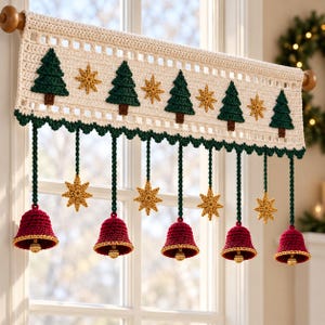 May include: A cream-coloured crochet window valance featuring a row of dark green pine trees and gold stars. Below the valance, five dark green crocheted cords hang down, each ending in a red bell with a gold rim and a small gold bead clapper.