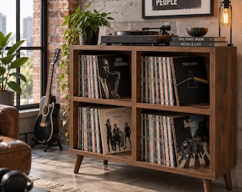 May include: A dark wood four-compartment record storage cabinet with tapered legs, filled with vinyl records including John Coltrane, Pink Floyd, Fleetwood Mac, and The Beatles. A black turntable sits on top, alongside two books and a small bowl.