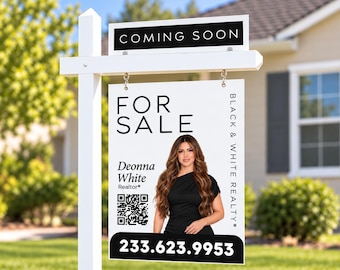 May include: A white real estate sign on a post featuring the text COMING SOON, FOR SALE, BLACK & WHITE REALTY, and 233.623.9953. It includes a photograph of a person with long brown hair, the name Deonna White, and a QR code.
