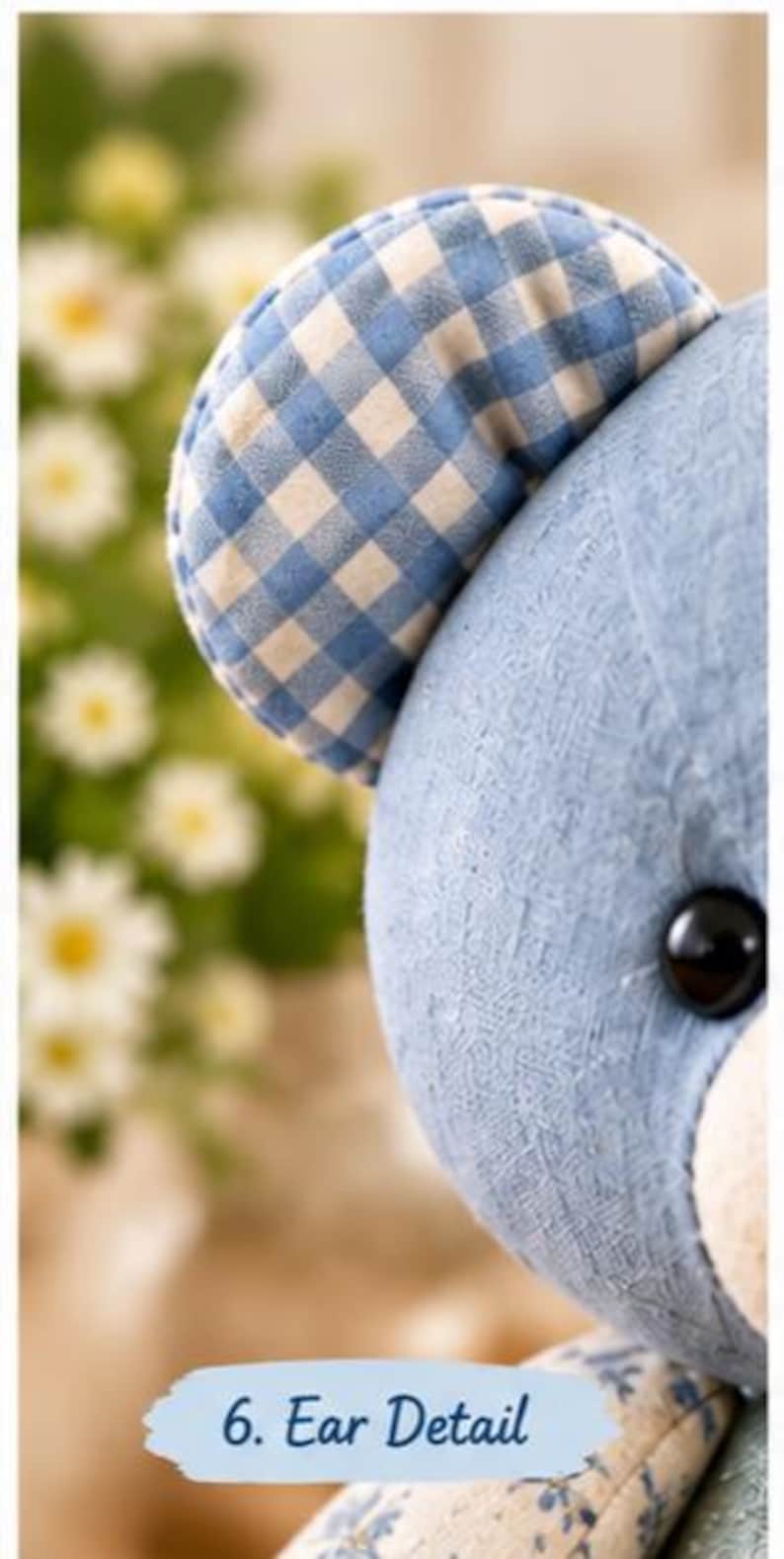 May include: A plush toy bear featuring a blue textured fabric head and a rounded ear with a blue and white gingham check pattern. The bear has a shiny black button eye and a light-coloured muzzle. The text 6. Ear Detail is visible.