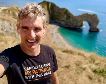 May include: A black short-sleeved t-shirt featuring the white and orange text "RAPIDLY LOSING MY PATIENCE WITH THIS RACE" printed on the chest. The shirt has a crew neckline and is made of a solid black fabric with clear, bold lettering.