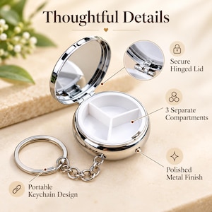 May include: A round, silver-colored metal pill case with a polished finish and a keychain attachment. The case features a hinged lid with an interior mirror and a white plastic insert divided into three separate compartments for storage.