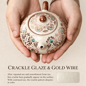 May include: A round ceramic teapot with a cream-colored base, featuring a brown and teal peacock-inspired pattern. The lid has a brown knob, and the spout is centered. Text reads: CRACKLE GLAZE & GOLD WIRE. After repeated use and nourishment from tea, fine crackle lines gradually appear on the surface. With continued use, the crackle pattern deepens in color.