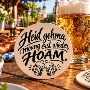以下が含まれることがあります： 「Heid gehma moang erst wieder HOAM.」という黒い筆記体の文字が書かれた、丸い明るい色のコースター。文字の下には、泡が溢れる2つのビールジョッキが乾杯しているグラフィックイラストが描かれています。