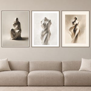 May include: A set of three framed wall art prints featuring monochromatic, sculptural figures draped in flowing fabric. The left print shows a seated figure, the center shows a torso, and the right shows a standing figure, all in shades of beige.