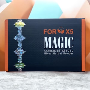 Könnte beinhalten: Eine rechteckige schwarze Schachtel mit der Aufschrift FOR X5 MAGIC Mixed Herbal Powder. Die Vorderseite zeigt orangen Text, ein Wabenmuster und einen vertikalen holografischen Sicherheitsstreifen links mit mehreren Etiketten FOR X5 und ORIGINAL SECURITY.
