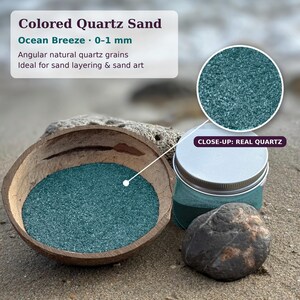 Coconut shell bowl of Ocean Breeze turquoise sand and a closed jar on a beach, with a close-up circle of the quartz grains