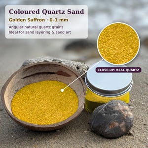 Może przedstawiać: Kolorowy piasek kwarcowy Golden Saffron z ziarnami naturalnymi o kątowym kształcie 0-1 mm. Piasek znajduje się w brązowej miseczce z łupiny kokosa oraz w przezroczystym szklanym słoiku ze srebrną nakrętką, obok ciemnoszarego kamienia.