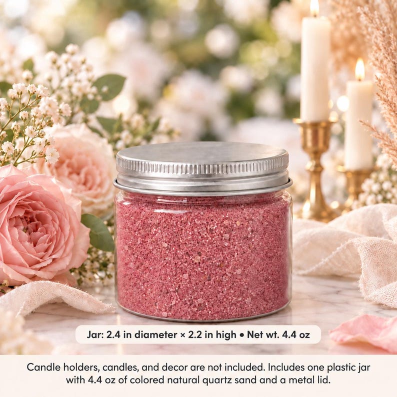 Closed clear jar of rose pink colored quartz sand with a silver metal screw lid on a marble table, surrounded by pink roses, baby's breath, lit white candles in brass holders and cream fabric. Text: Jar: 2.4 in diameter x 2.2 in high, Net wt. 4.4 oz. Candle holders, candles, and decor are not included. Includes one plastic jar with 4.4 oz of colored natural quartz sand and a metal lid.