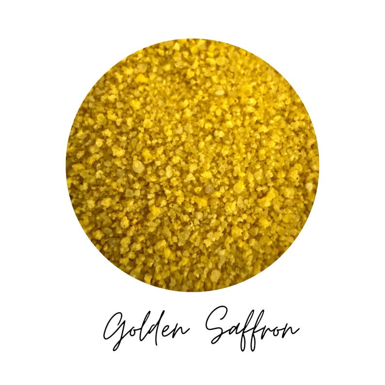 Close-up circle swatch of Golden Saffron yellow craft sand with the color name written below
