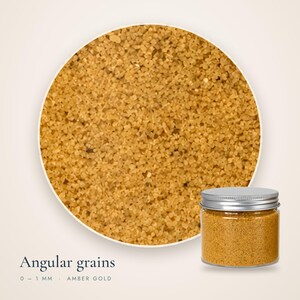 Close-up view of angular 0-1 mm Amber Gold colored quartz sand grains next to a clear
plastic jar with a metal lid for dry terrarium styling.
