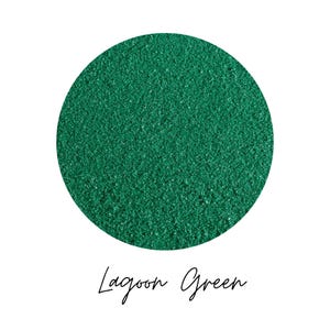 Close-up circle swatch of Lagoon Green emerald craft sand with the color name written below
