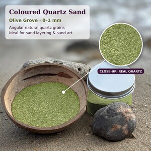 K&ouml;nnte beinhalten: Olivgr&uuml;ner Quarzsand mit 0-1 mm gro&szlig;en, kantigen Naturk&ouml;rnern. Der Sand befindet sich in einer braunen Kokosnussschale und einem durchsichtigen Kunststoffglas mit silbernem Deckel. Ein kreisf&ouml;rmiger Ausschnitt zeigt den echten Quarz.