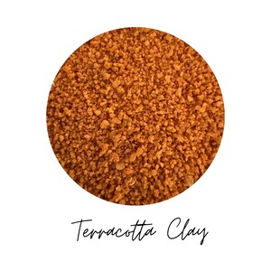 Close-up circle of Terracotta Clay colored quartz sand showing warm orange brown grains, with the color name Terracotta Clay written in script below, on a white background.