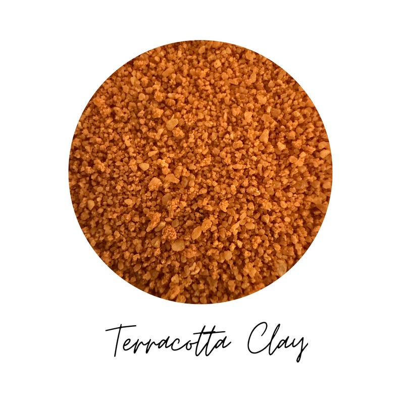 Close-up circle of Terracotta Clay colored quartz sand showing warm orange brown grains, with the color name Terracotta Clay written in script below, on a white background.