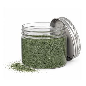 Open jar of Forest Moss green craft sand with its silver lid leaning on the side and a little sand spilled in front