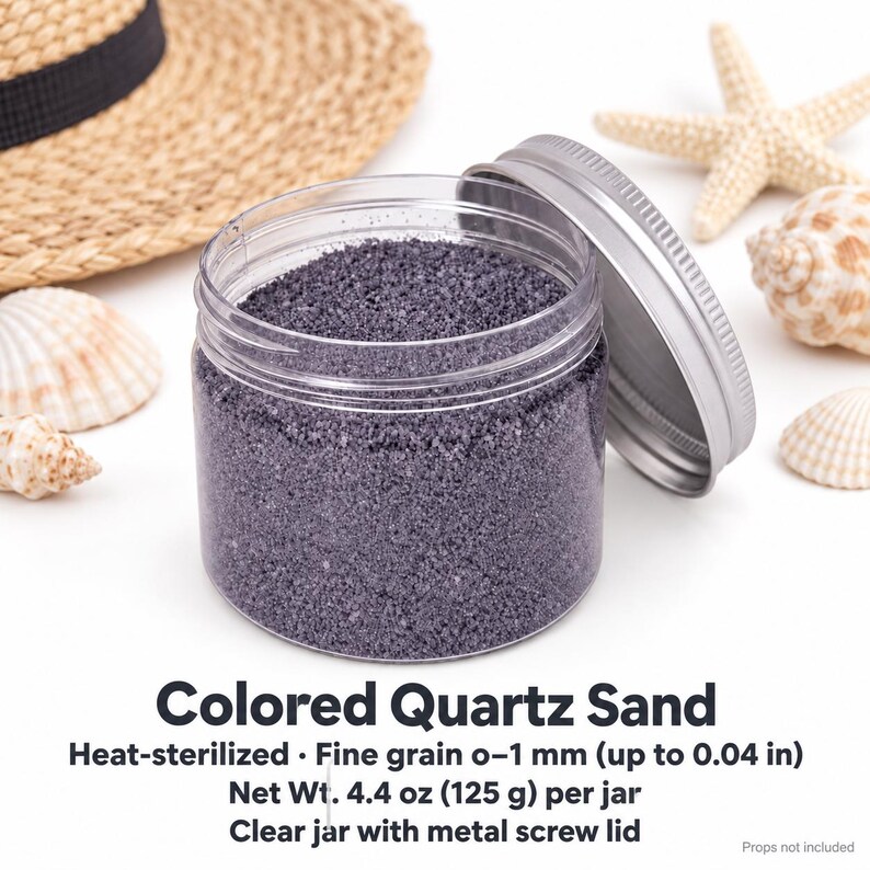 Open clear jar of Lavender Mist colored quartz sand in a soft lavender grey, with the silver metal lid leaning against it, next to a straw hat, seashells and a starfish. Text: Colored Quartz Sand, heat-sterilized, fine grain 0-1 mm (up to 0.04 in), Net Wt. 4.4 oz (125 g) per jar, clear jar with metal screw lid, props not included.