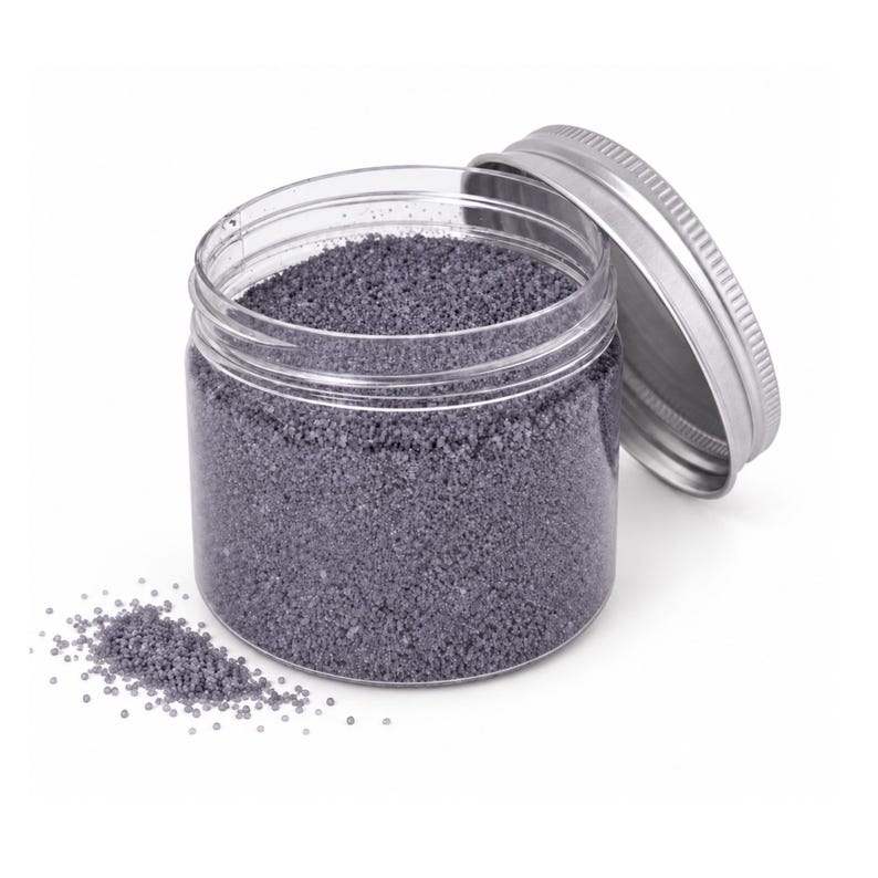Open jar of Lavender Mist gray-purple craft sand with its silver lid leaning on the side and a little sand spilled in front