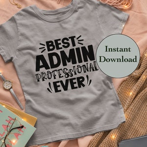 May include: A gray t-shirt with black text that reads "Best Admin Professional Ever!"  The shirt is on a pink and brown blanket with string lights.