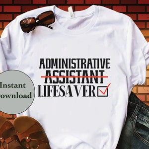 May include: White t-shirt with black text that reads "ADMINISTRATIVE ASSISTANT" with a red line through "ASSISTANT" and a checkmark next to "LIFESAVER".
