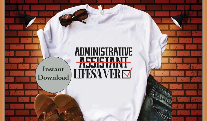 May include: White t-shirt with black text that reads "ADMINISTRATIVE ASSISTANT" with a red line through "ASSISTANT" and a checkmark next to "LIFESAVER".