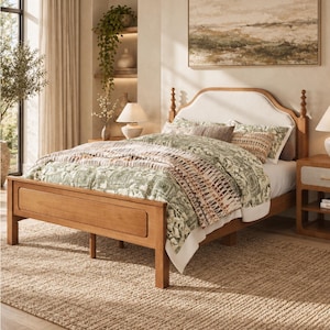 May include: A wooden bed frame with a curved, upholstered headboard in a light cream fabric. The bed is dressed in a patterned green and white duvet cover with matching pillows. Two wooden nightstands with drawers and open shelves sit on either side.