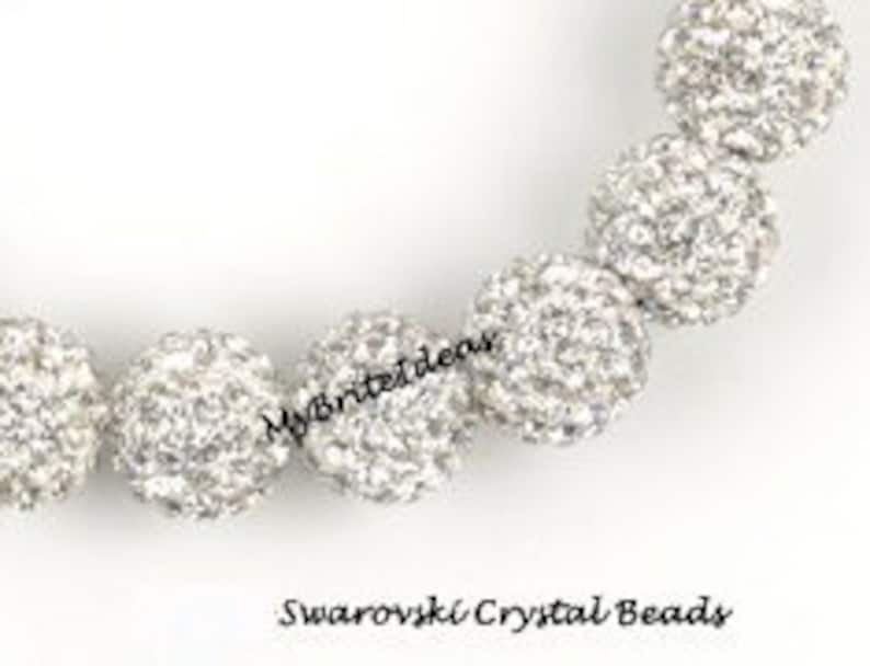 K&ouml;nnte beinhalten: Nahaufnahme einer Kette aus silbernen Swarovski-Kristallperlen. Die Perlen sind rund und mit kleinen, funkelnden Kristallen bedeckt. Der Text "MyBriteIdeas" und "Swarovski Crystal Beads" sind sichtbar.