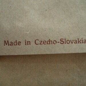 May include: A close-up of a brown paper bag with the text "Made in Czecho-Slovakia." printed in brown ink.