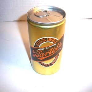May include: A gold aluminum can of Bartel's Pure Beer with a black and orange label. The label says "Since 1899 Original and Genuine Bartel's Pure Beer".