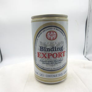 May include: A cylindrical Binding Export beer can. The can is white with gold and red accents. The text "Binding Export" is prominently displayed. The can contains 33 cl.