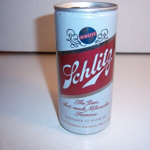 May include: A vintage aluminum can of Schlitz beer. The can is blue and white with red lettering. The text on the can reads "Schlitz, The Beer that made Milwaukee Famous, Contents 12 Fluid Oz."