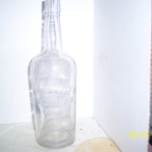 May include: A clear glass bottle with a textured surface. The bottle has the text "W.W. GENTRY CO. BEDFORD, VA." etched on the side.