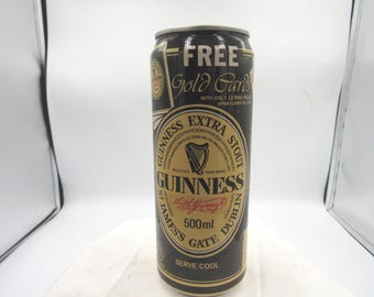May include: A black and gold Guinness Extra Stout can with the text "FREE Gold Cards" at the top. The can features a gold label with the Guinness logo, a harp, and the text "500ml".
