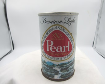 Könnte beinhalten: Vintage Pearl Bierdose. Die Dose ist weiß mit einem rot-weißen ovalen Logo mit der Aufschrift "Pearl" und "Fine Lager Beer". Die Dose hat auch eine Landschaftsillustration am Boden und die Worte "Premium Light".