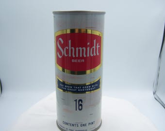 May include: A vintage Schmidt Beer can. The can is silver with a red and gold label that reads "Schmidt BEER". Below the label is a blue banner with white text. The can also has the number "16" printed on it. The can contains one pint.