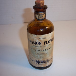May include: An amber glass bottle with a cork stopper, featuring a cream-colored label that reads Passion Flower, Passiflora Incarnata, Fluidextract, Alcohol 40%, No. 1486, and The Wm. S. Merrell Company, Cincinnati, U.S.A., with a One-Quarter Pint neck label.