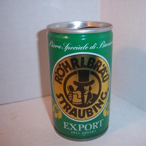 May include: A green aluminum can of Röhrlbräu Straubing Export beer. The can has a gold label with a black and white illustration of a man in a top hat holding a beer stein. The text on the label reads "Birra Speciale di Baviera" and "Export Hell - Chiara".