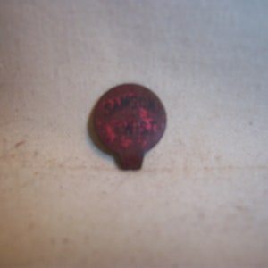 May include: A red metal bottle cap with black lettering that reads "GASOLINE 1/2 PINT".