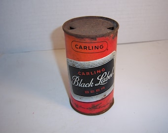 Könnte beinhalten: Eine rostige Vintage-Aluminiumdose Carling Black Label Bier. Die Dose ist rot mit schwarzen und weißen Buchstaben und einem schwarzen Etikett mit weißen Buchstaben, auf dem "Carling Black Label Beer" steht.
