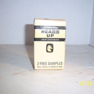 May include: A white box with black text that reads "Gillette Heads Up Hair Grooming" and a unicorn logo. The box also says "2 Free Samples Your choice in bottle or tube."