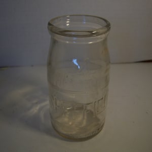 May include: A clear glass jar with a textured surface and the word "Suffolk" embossed on the side.