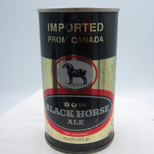 May include: Vintage Dow Black Horse Ale can. The can is black and gold with a red and black oval label featuring a horse silhouette. The text "IMPORTED FROM CANADA" is printed on the can.