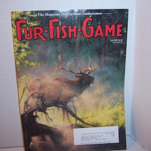 May include: A magazine cover for Fur-Fish-Game, featuring a large elk in a forest setting. The magazine title is in red letters. The background shows trees and a misty atmosphere. The magazine is dated July 2002.
