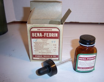 May include: A vintage Bena-Fedrin medicine set including a cardboard box, an amber glass bottle with a black cap, and a glass dropper with a black rubber bulb. The box and bottle labels feature the text Bena-Fedrin and Parke, Davis & Co.
