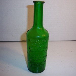 May include: A green glass bottle with the text "Sweet Flag Extract, Part Used, Sassafras Root, This Extract is Prepared from the Root of Sassafras, Part Used, Root" embossed on the side.