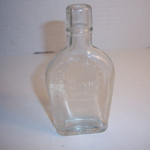 May include: Clear glass bottle with a square base and a rounded body. The bottle has a label that reads "ESTABLISHED 1858" and "THE SUPERIOR OIL CO. ST. LOUIS, MO."