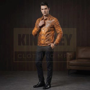 May include: A long-sleeved, button-down jacket in a tan and brown snakeskin-textured pattern, paired with slim-fit dark charcoal trousers and black leather boots. The jacket features a pointed collar, buttoned cuffs, and a central button closure.