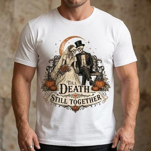 May include: A white short-sleeve t-shirt featuring a graphic of two skeletons dressed as a bride and groom sitting on a bench under a crescent moon. The text reads Till Death... Still Together, surrounded by pumpkins and decorative flourishes.