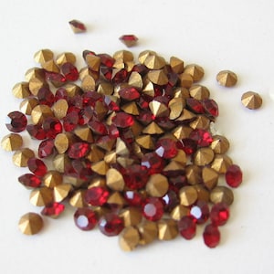May include: A pile of red and gold rhinestones, perfect for crafting and jewelry making.