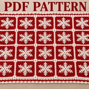 May include: A rectangular crochet blanket featuring a grid of twenty red squares, each centered with a white snowflake motif. The blanket is bordered by a white scalloped edge. The text PDF PATTERN is displayed in red above the blanket.